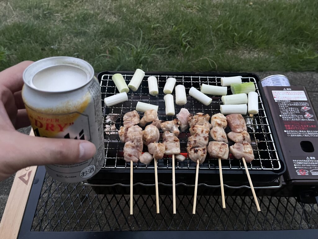 焼き鳥を焼きながらビールを楽しむおやじの手元
