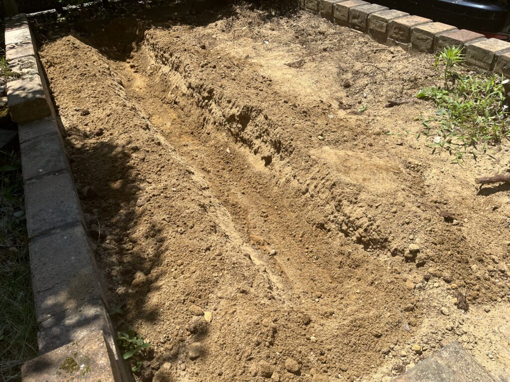 ネギの植え付け準備中のウッドデッキ跡地。20cmほどの溝を掘った状態