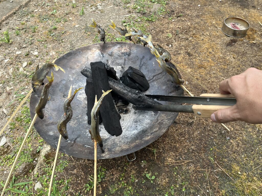 スノーピークの火ばさみで炭を掴んでいる様子