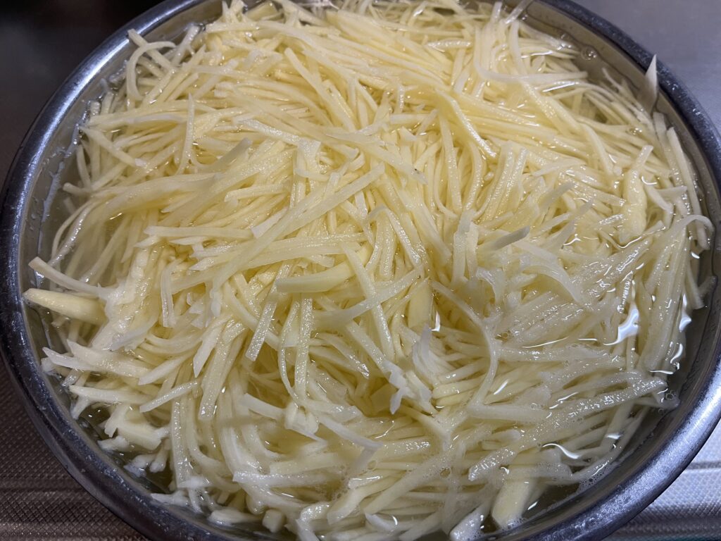 切ったジャガイモのでんぷんを落としている様子