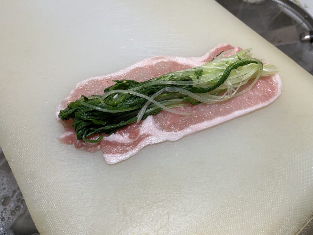 2枚重ねた豚肉の上に水菜を乗せた様子