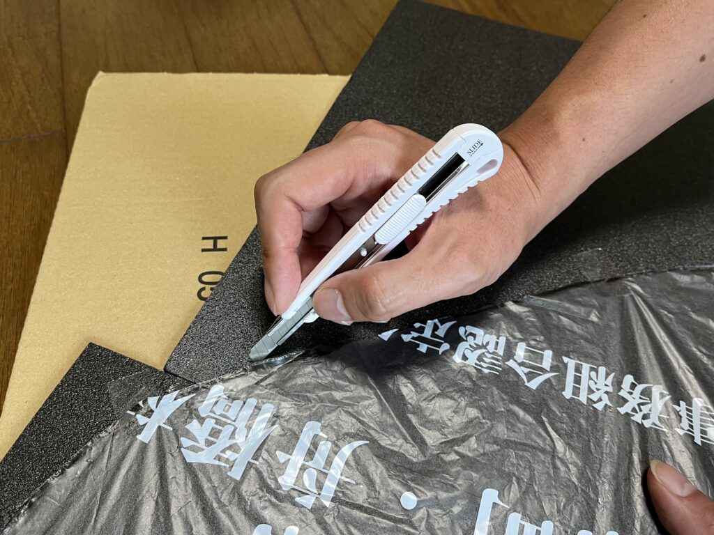 型紙に合わせてカラーボードをカットしている様子