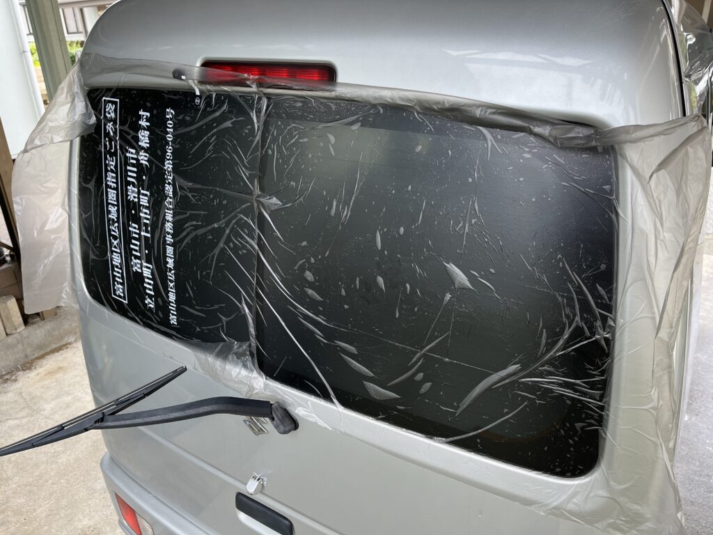 外から霧吹きでゴミ袋を貼り付けて型取りしている様子