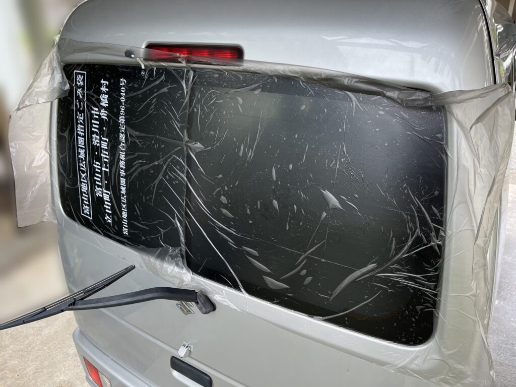 外から霧吹きでゴミ袋を貼り付けて型取りしている様子
