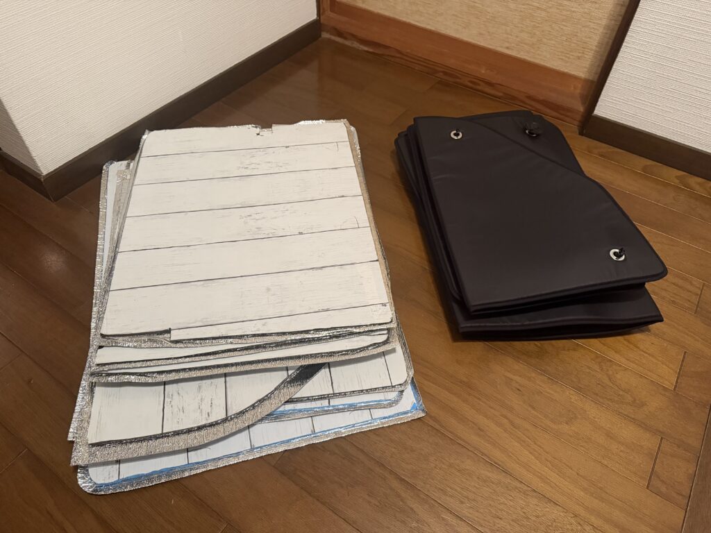 床に置いた100均DIYサンシェード一式と、折りたたんだ趣味職人サンシェードを並べて収納サイズを比較している様子