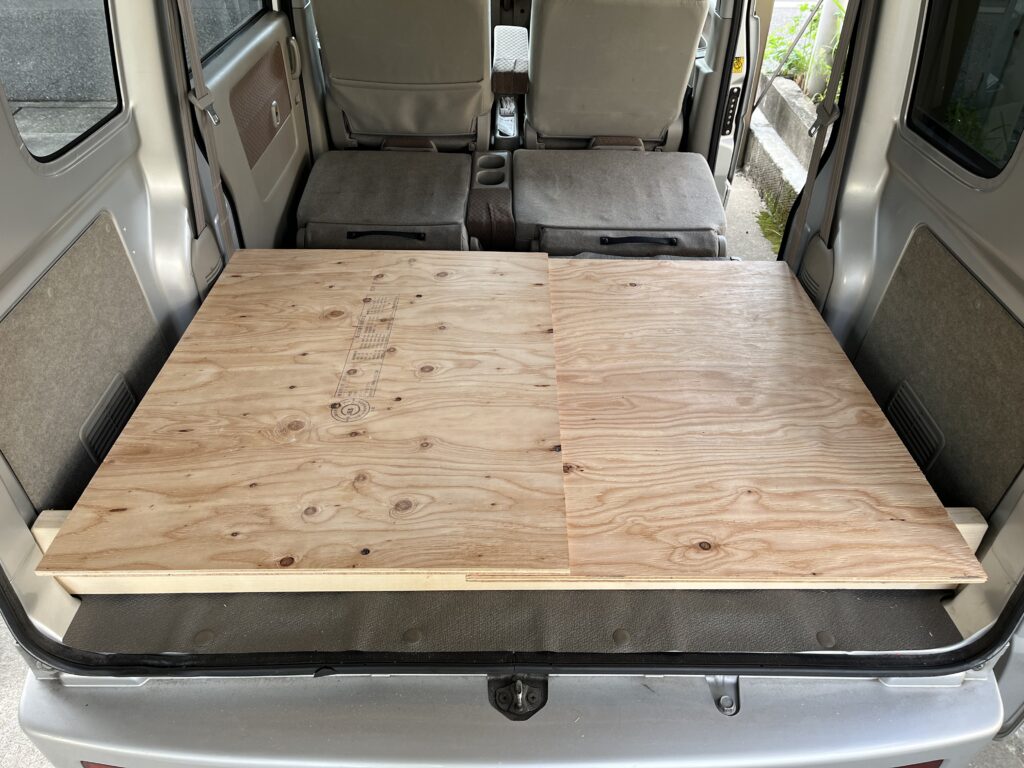 切り出した2枚の合板を仮に車内に乗せてみている様子