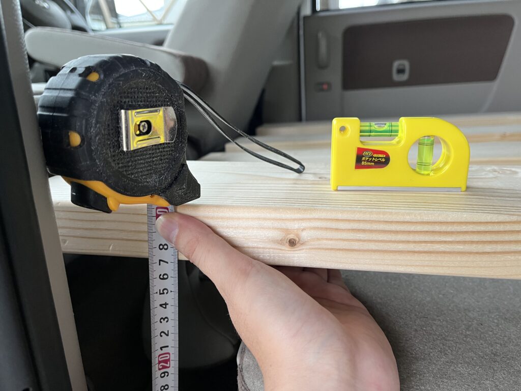 前部土台の足の長さを水平器を使って計測している様子