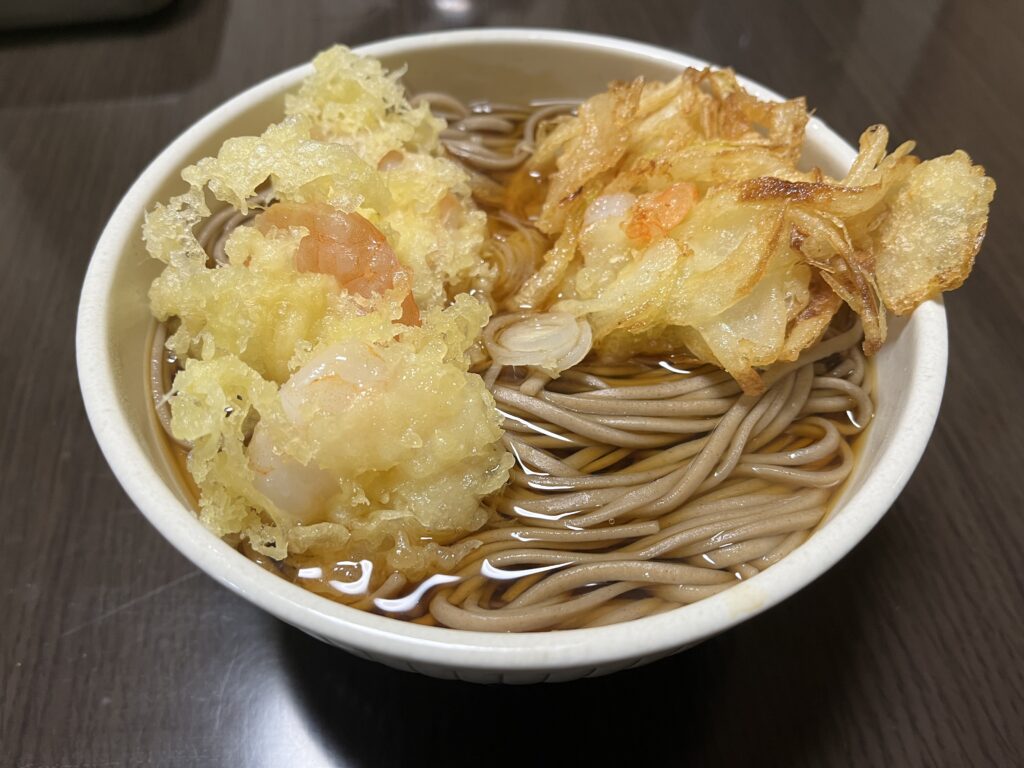 かけそばに揚げたて天ぷらを乗せた様子