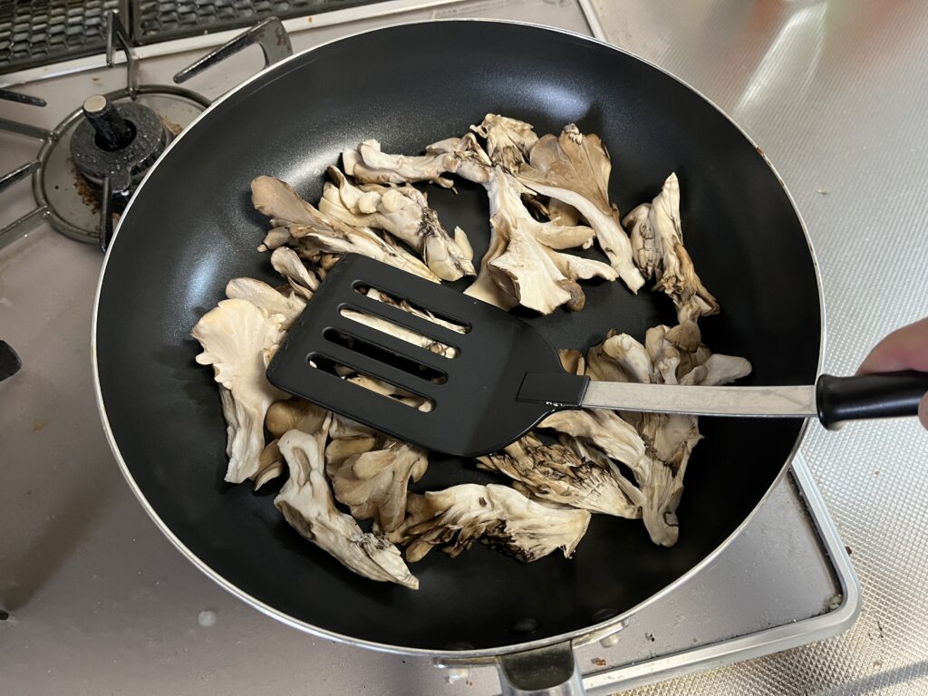 フライパンに舞茸を押しつけて焼いている様子