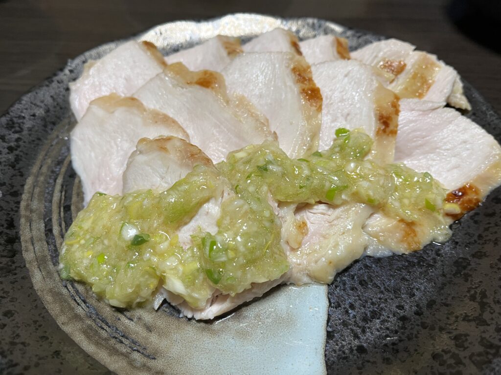しっとり焼いた鶏むね肉に自家製ネギ塩だれをかけた様子