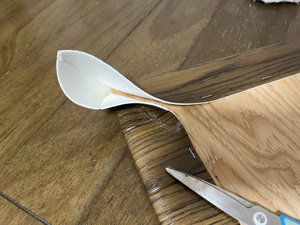 クッションフロアが余って重なっている部分に折り目をつけている様子