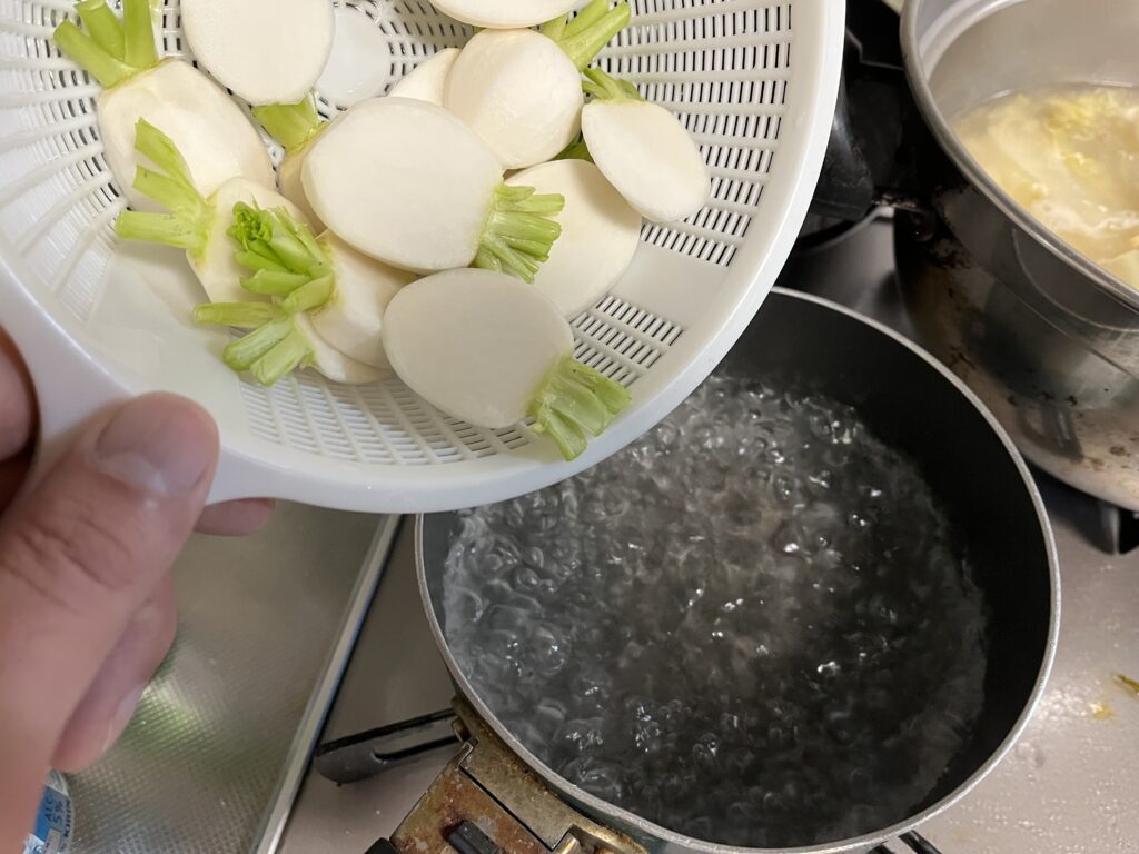 沸騰したお湯にスライスした小カブを入れる様子