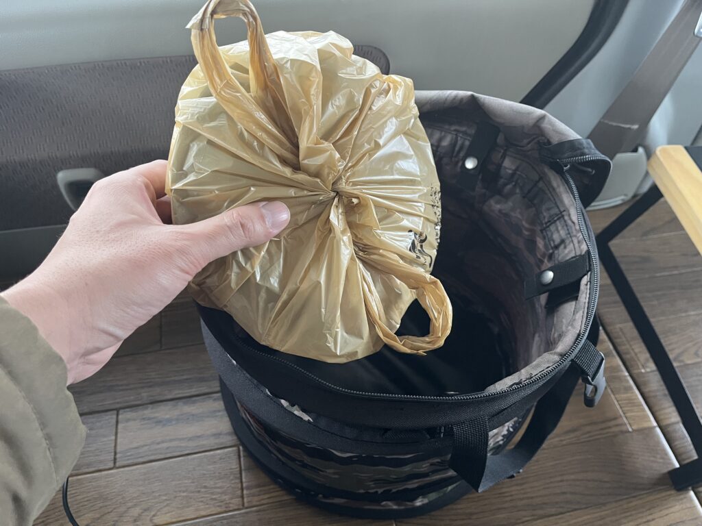 食べ終わったカレーの容器をゴミ箱へ入れている様子