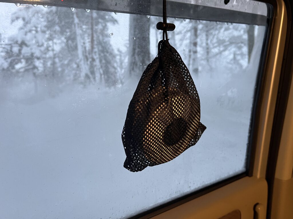 一酸化炭素チェッカーをネットに入れ、車内にぶら下げている様子