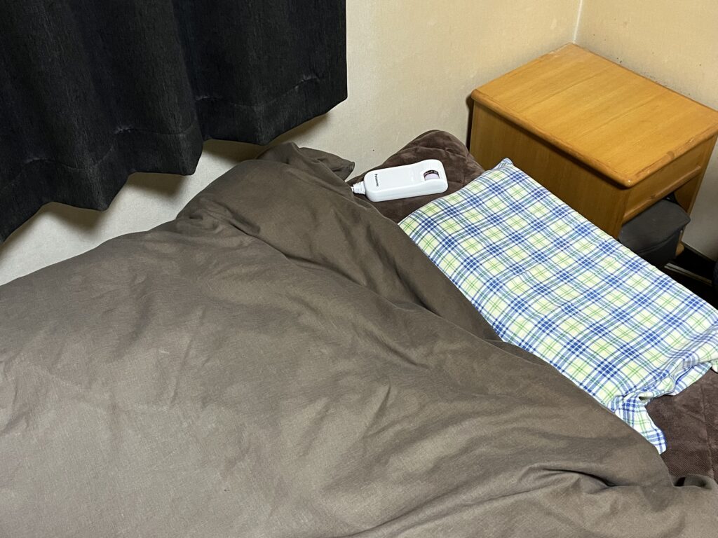 自宅のベッドで電気しき毛布を使用している様子
