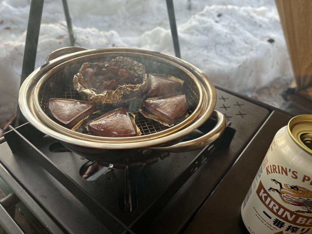 ナッツとチーズを燻製にする雪中キャンプのつまみ。