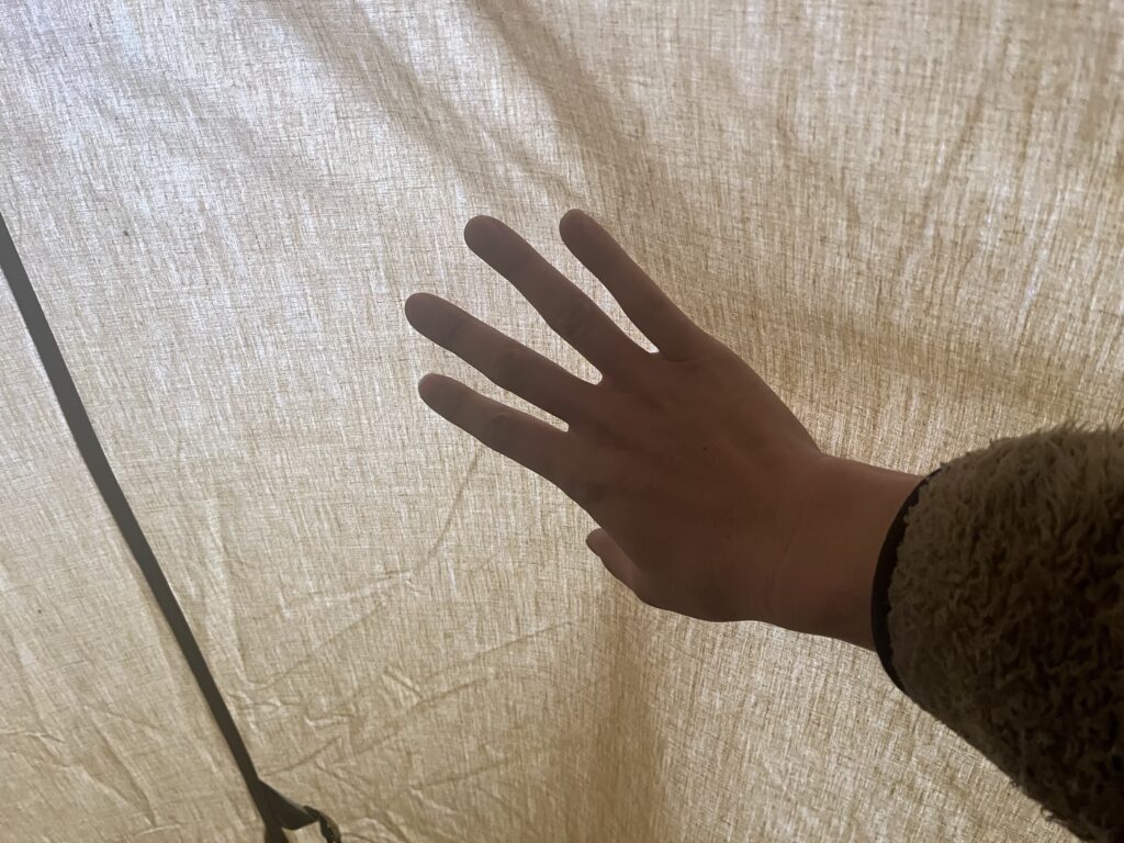 テント内側を手で触って結露を確認している様子
