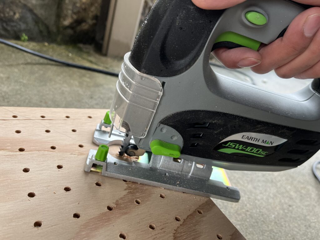 マーキングした線に沿ってジグソーで有孔ボードをカットしている様子