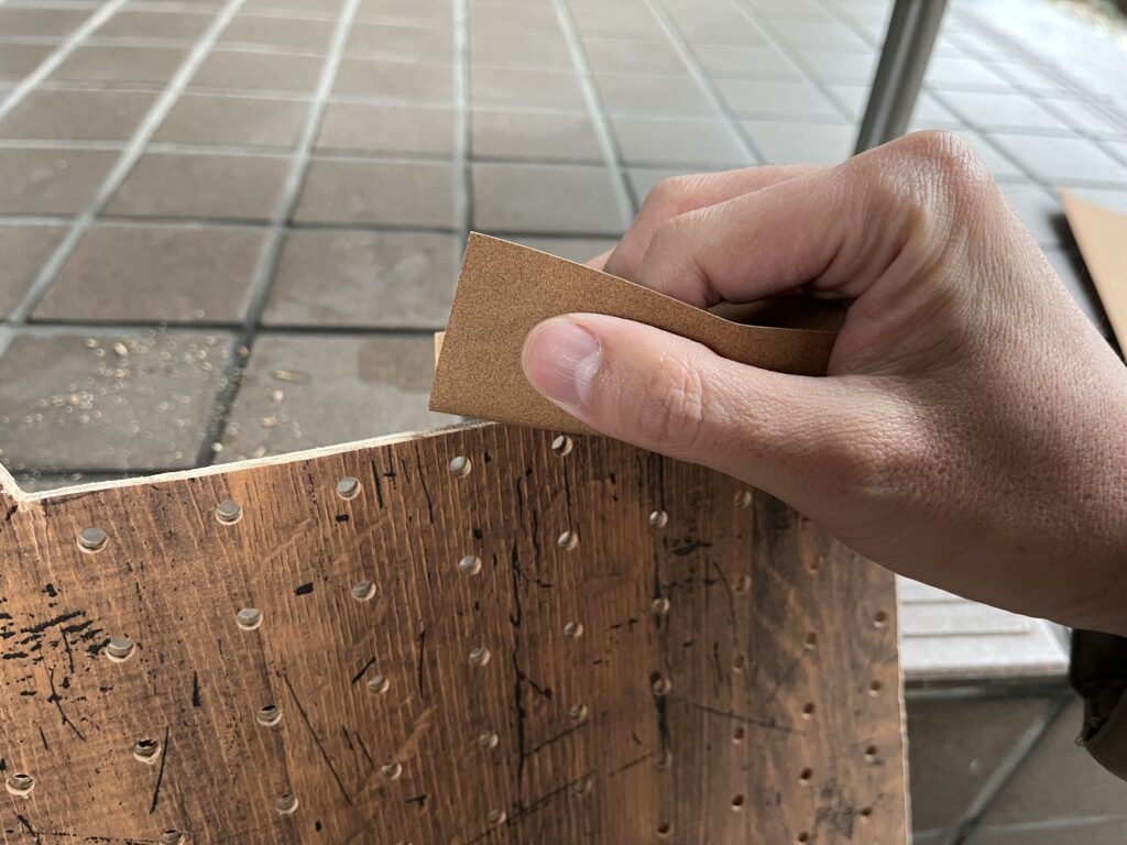 切り出したボードをサンドペーパーで滑らかにしている様子