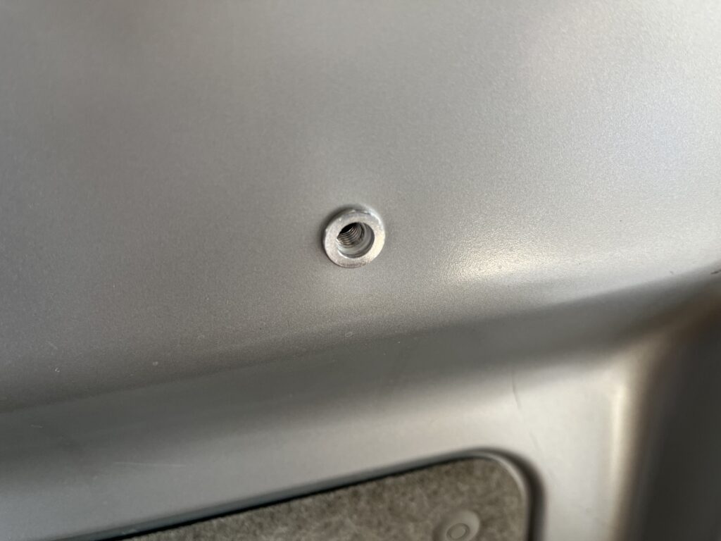 ボディの鉄板にアルミナットがかしめられている様子