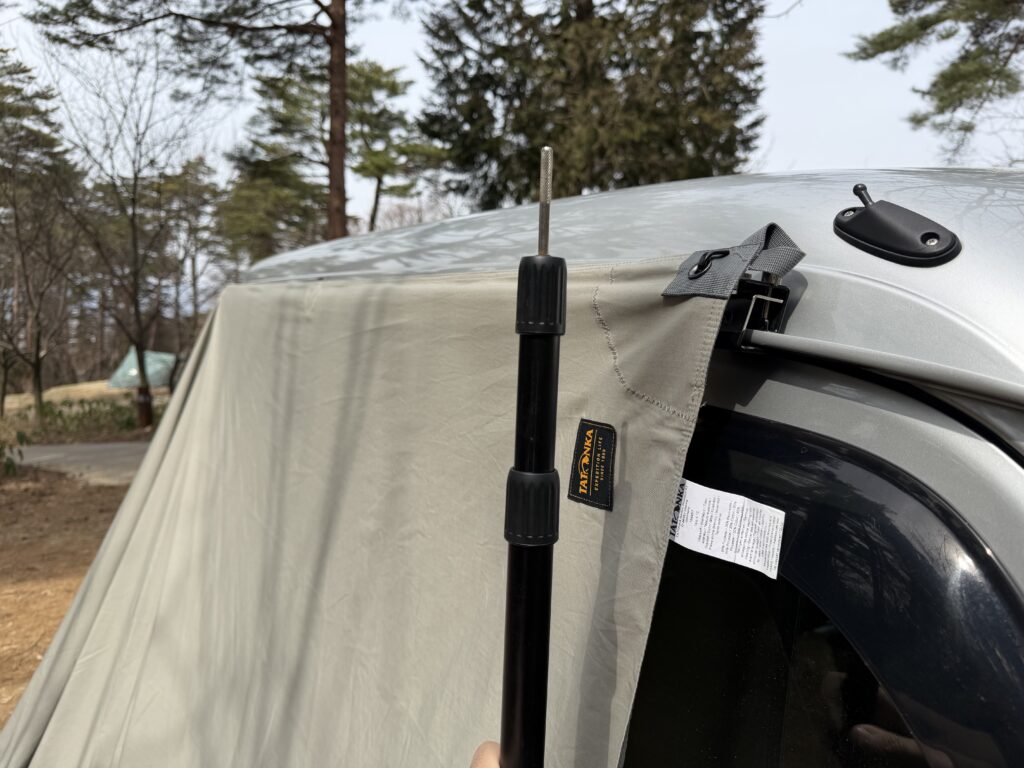 伸縮ポールの長さをカージョイントと同じ高さになるように調整している様子