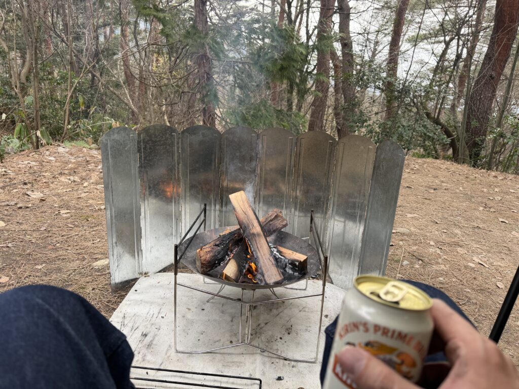 焚き火をしながらビールを飲んでいる様子