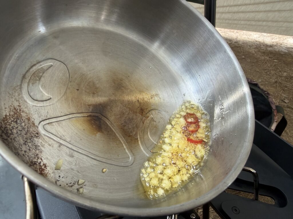 ニンニクと鷹の爪をオリーブオイルでじっくり加熱している様子