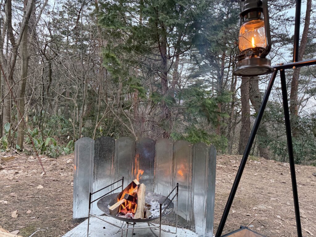 少し肌寒くなってきた時間帯にオイルランタンを灯し、焚き火に再び火を入れた様子