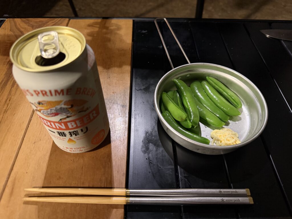 茹でたてのスナップエンドウでビールを飲む様子