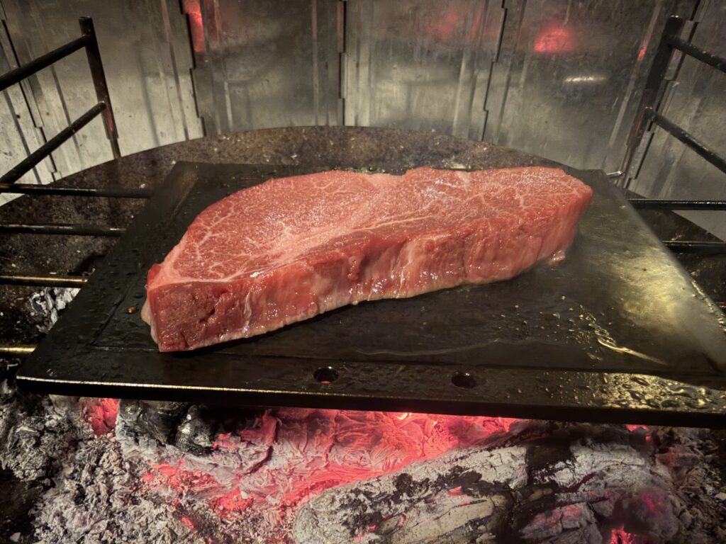 熱々の鉄板に飛騨牛ヒレステーキをのせた様子