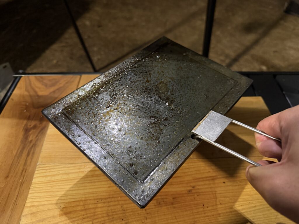 ハンドルを差し込んで鉄板を持ち上げている様子