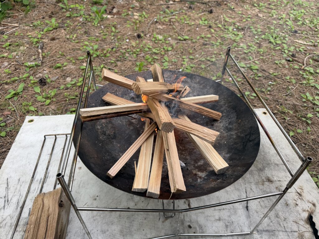 焚き火台の上で細かく割った薪に火がつき、炎が上がり始めている様子