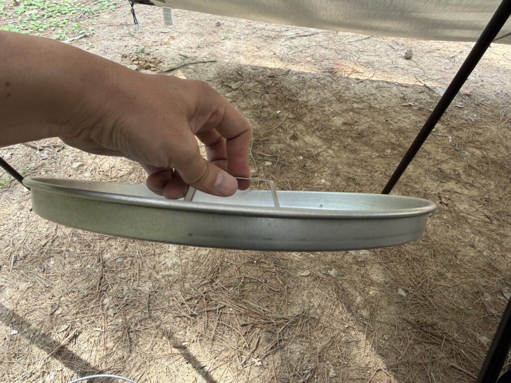 ピザグリルのフタを手で持ち上げ、わずかな歪みが出ている様子を確認している写真