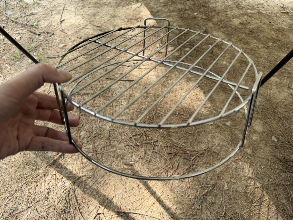 キャプテンスタッグUG-2900に付属する円形のファイアースタンドを手に持って確認している様子