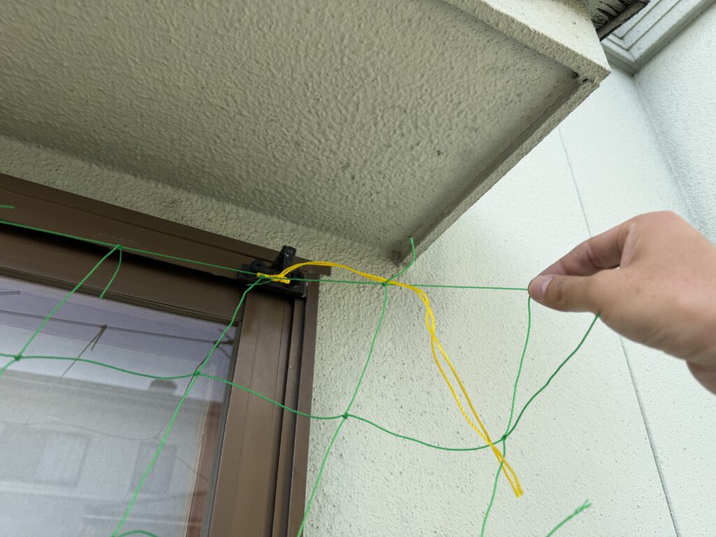 サッシのネット固定金具に取り付けた100均ネットが2列余っている様子