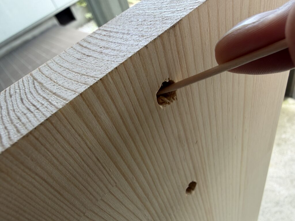 下穴に残った木くずを爪楊枝で取り除いている様子