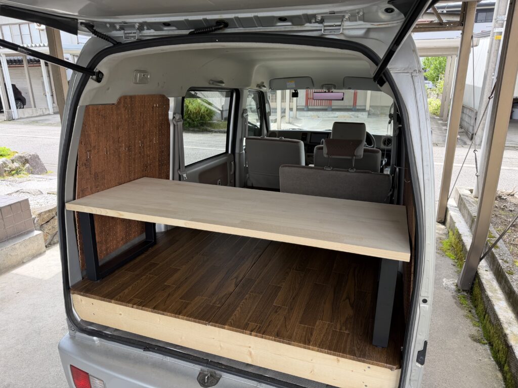 仮組みした自作テーブルをエブリイ車内に設置し、サイズ感を確認している様子