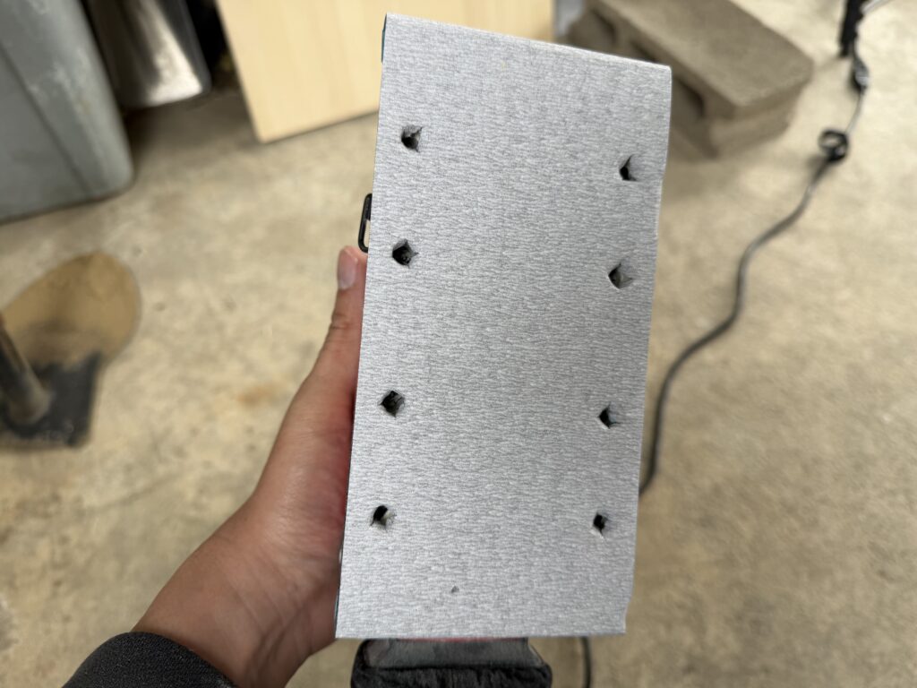 サンダー用のサンドペーパーに専用治具を使って集塵穴を開けた様子