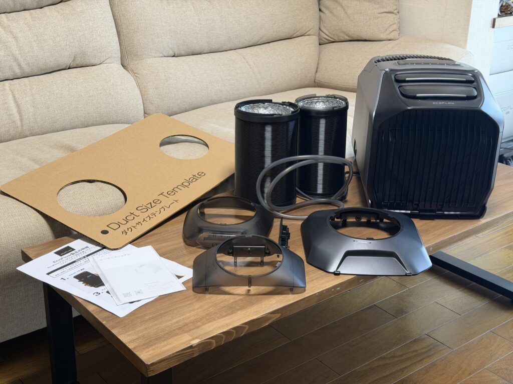 EcoFlow WAVE 3本体とダクト、アダプター、説明書などの付属品を並べた写真