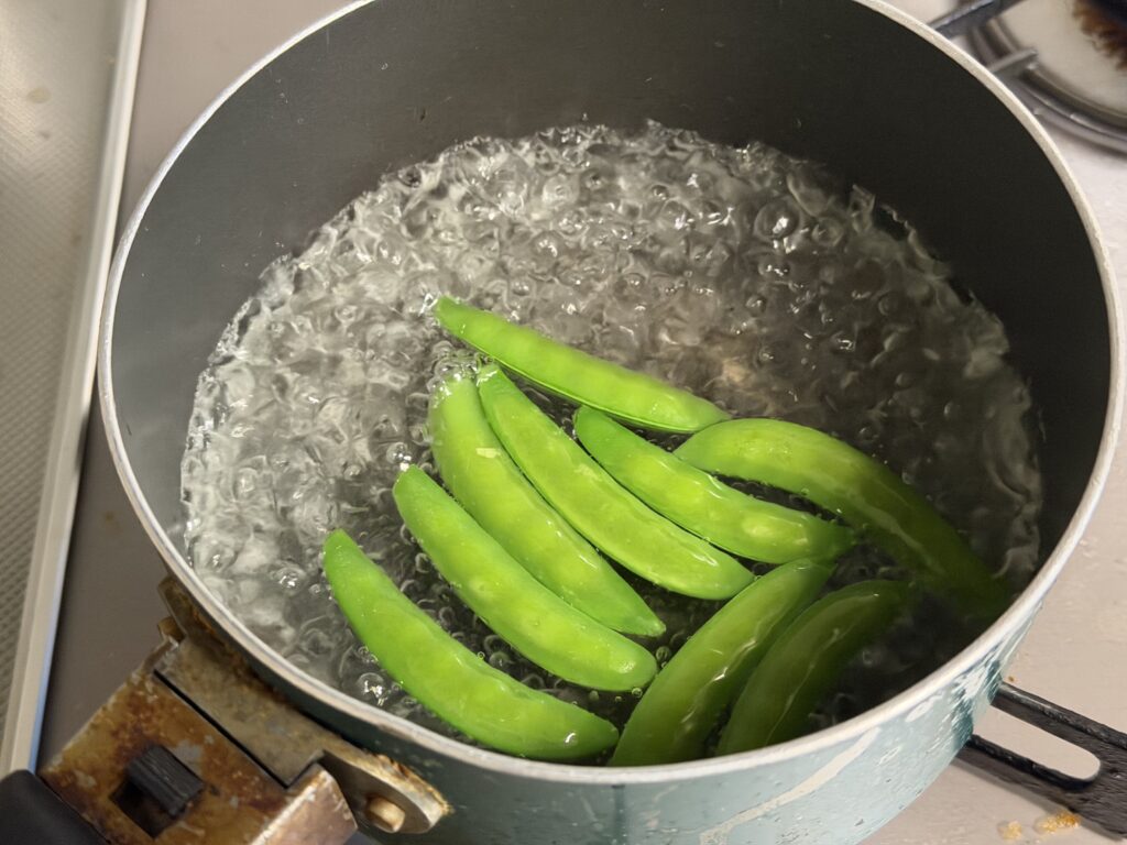 鍋でスナップエンドウを塩ゆでしている様子