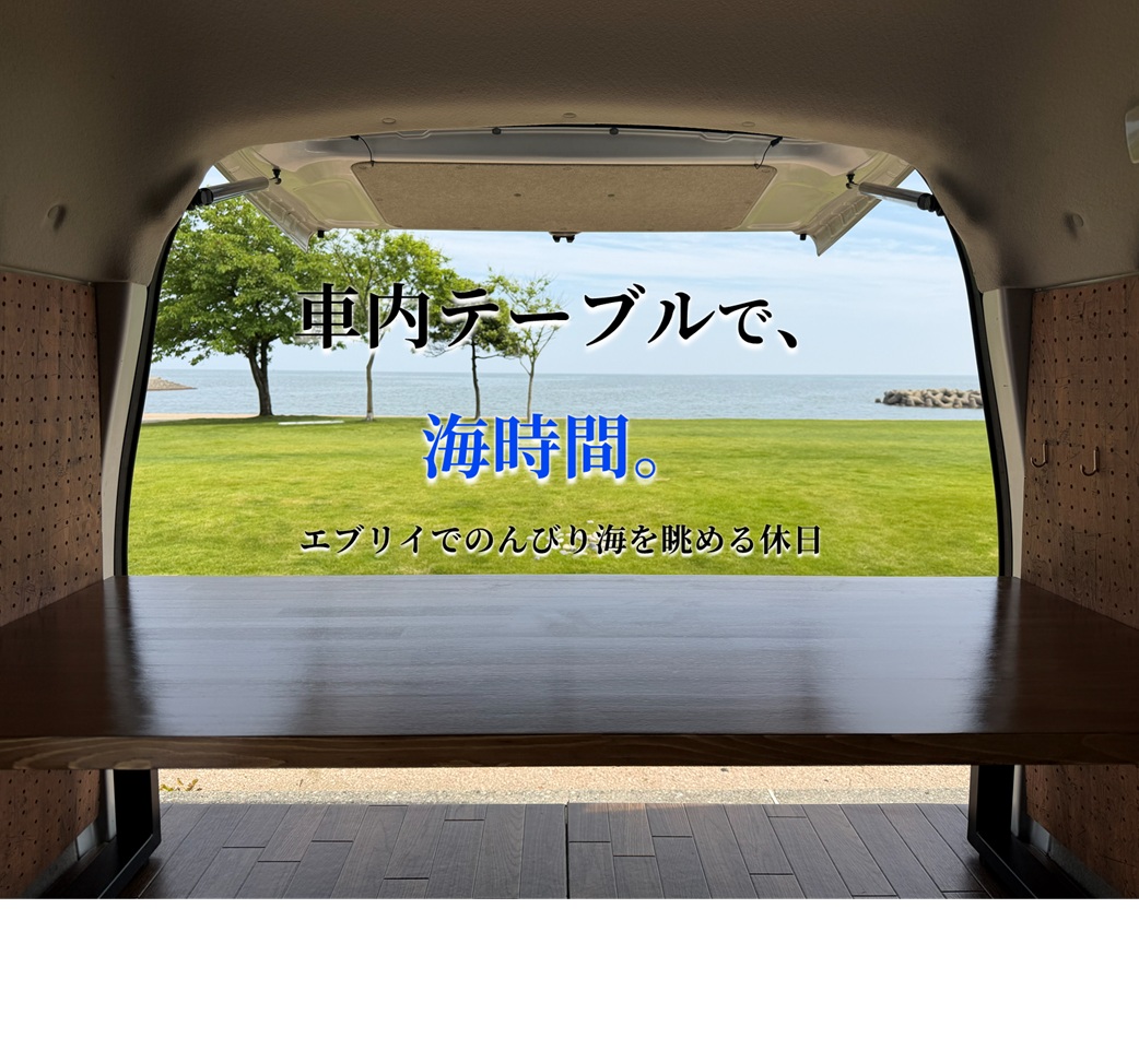 エブリイのバックドアを開けて赤松集成材の車内テーブル越しに海を眺める様子