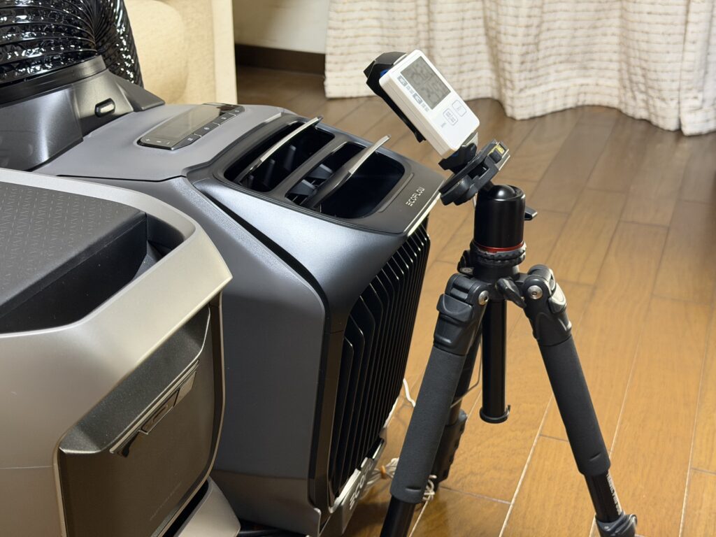 EcoFlow WAVE 3の冷風吹き出し口の前に、室内外温度計の本体を三脚で固定して設置している様子。