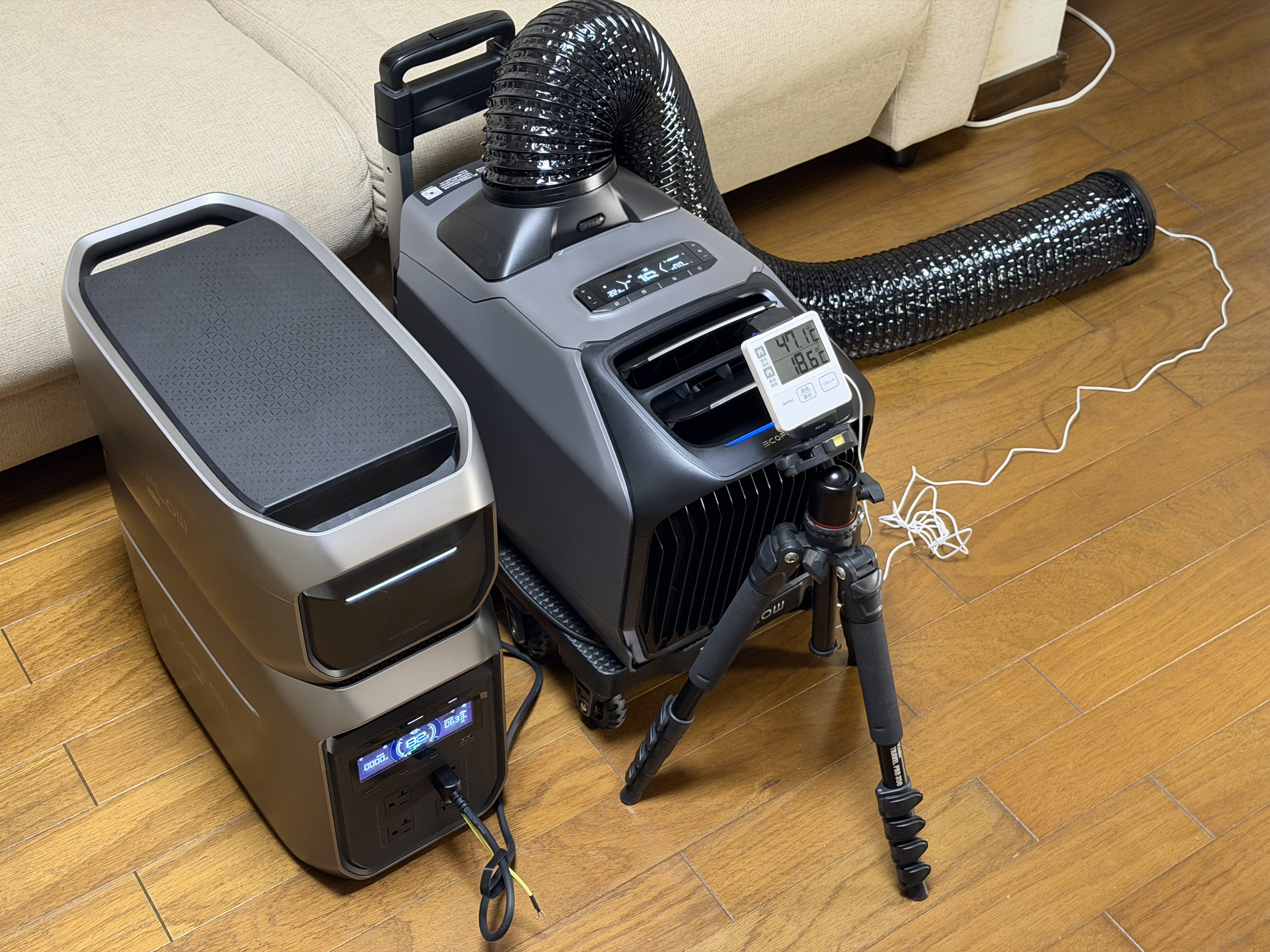 リビングでEcoFlow WAVE 3をポータブル電源に接続し、排熱ダクトを伸ばして室内外温度計で試運転している様子