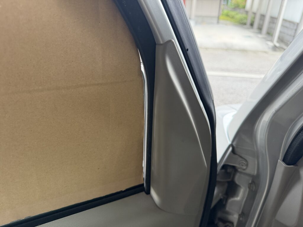 エブリイDA64Vの助手席窓にダンボール型紙を当てたところ、前側の窓枠部分に隙間ができている様子。