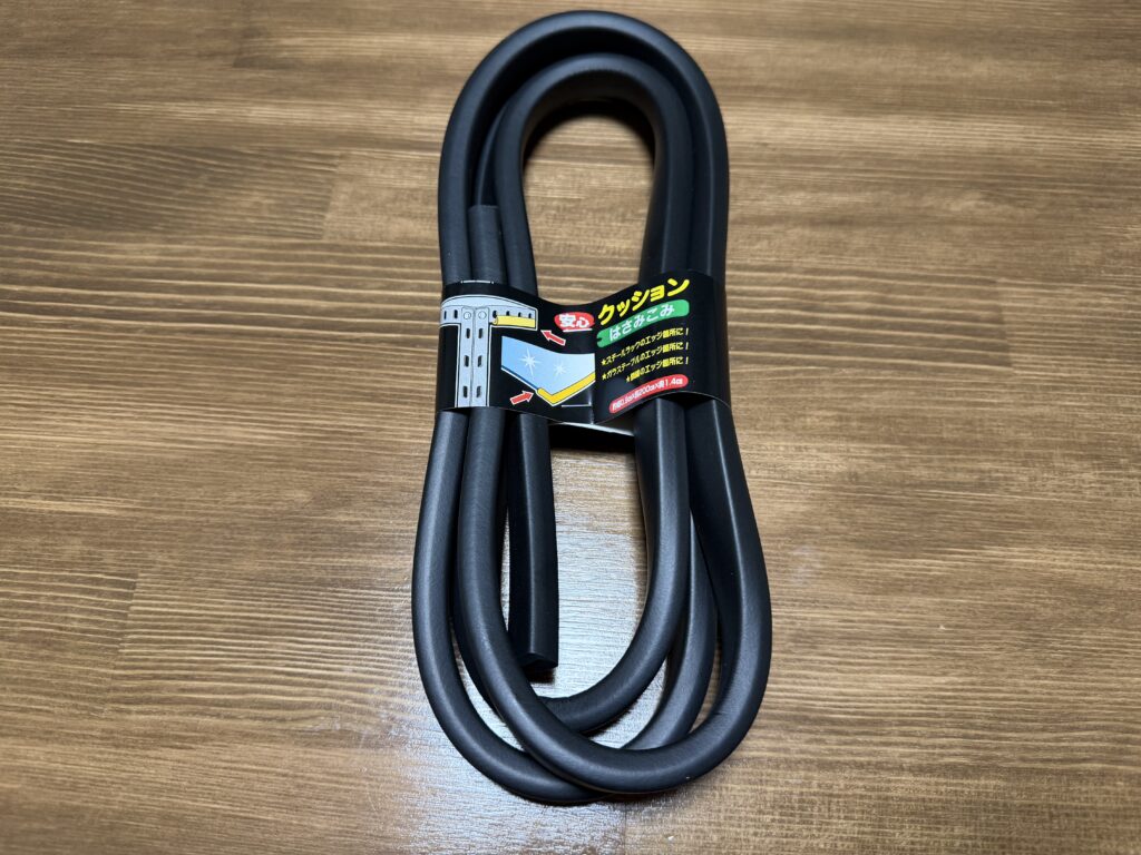 木目のテーブルの上に置いた黒いはさみ込みタイプのクッション材