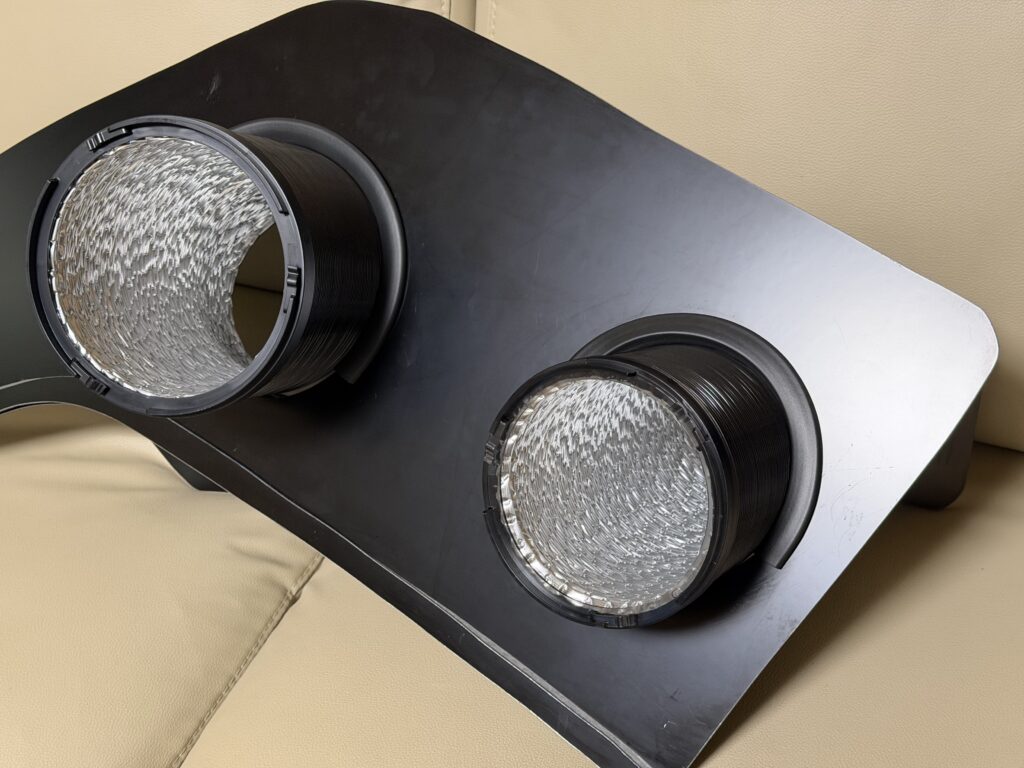 黒い窓パネルのダクト穴上部にクッション材を取り付け、EcoFlow WAVE 3のダクト2本を通した状態