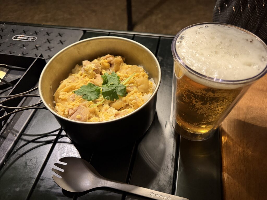 キャンプ用クッカーに盛り付けた親子丼とビール