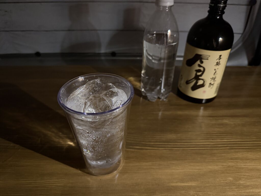 エブリイの自作車内テーブルに置いた芋焼酎のソーダ割り