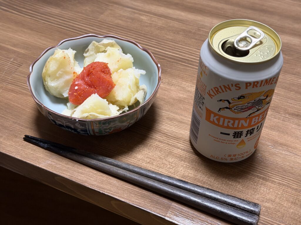 収穫したジャガイモにバターと明太子をのせ、ビールと一緒に食卓へ並べた様子