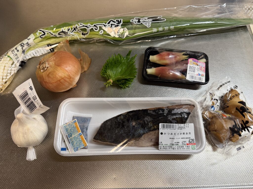 カツオのたたき、ねぎ、玉ねぎ、大葉、ミョウガ、にんにく、しょうがを並べた様子